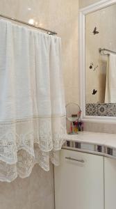 a bathroom with a shower curtain and a sink at NEFELI VILLA in Patitiri