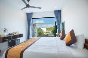 a bedroom with a large bed with a large window at Palm Beach Hotel Phú Yên 