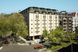 eine Aussicht über ein großes weißes Gebäude mit einem Parkplatz in der Unterkunft The Hoxton, Charlottenburg in Berlin