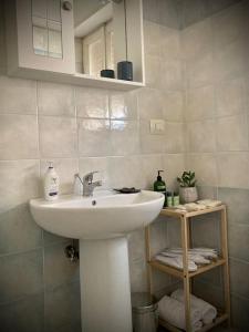 La salle de bains est pourvue d'un lavabo blanc et d'un miroir. dans l'établissement Chez Nous, à Ladispoli