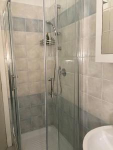 y baño con ducha y puerta de cristal. en Chez Nous, en Ladispoli