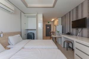 Habitación de hotel con 2 camas y escritorio en Staywell Hotel, en Busan