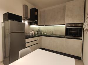 uma cozinha com um frigorífico de aço inoxidável e um lavatório em DolceVita Home em Civitanova Marche