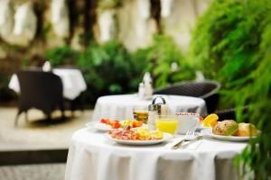 uma mesa com pratos de comida e bebidas em Hotel Prokop Square em Praga