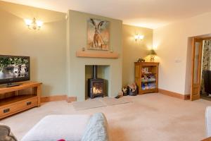 a living room with a fireplace and a tv at Lime Kiln Farm in Malton