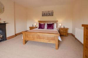 a bedroom with a wooden bed with purple pillows at Lime Kiln Farm in Malton