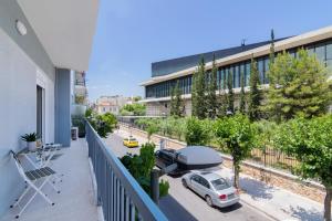 an apartment balcony with a car parked on a street at Spacious 2 Bedroom Apartment In Koukaki in Athens