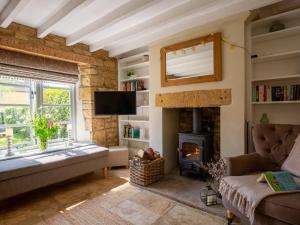 a living room with a fireplace and a couch at High Pump Cottage in Chipping Campden