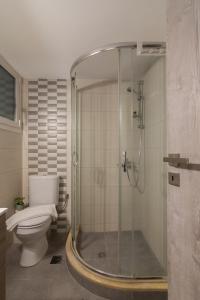 a bathroom with a toilet and a glass shower at Spacious 2 Bedroom Apartment In Koukaki in Athens