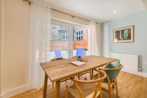 a dining room with a wooden table and chairs at StayLux Kensington in London