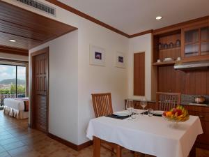 a kitchen with a table with a bowl of fruit on it at Sun Hill Hotel Patong in Patong Beach