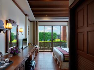 Sun Hill Hotel Patong في شاطيء باتونغ: غرفه فندقيه بسرير وشرفه