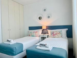 two beds in a room with a surprised face on the wall at ABC Expo Apartment in Lisbon