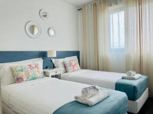 里斯本的住宿－ABC Expo Apartment，酒店客房设有两张床和窗户。