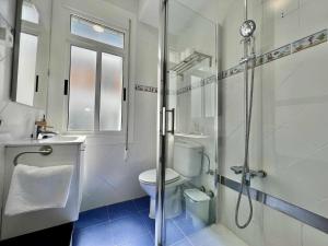 a white bathroom with a shower and a toilet at Green Door Coruña in A Coruña