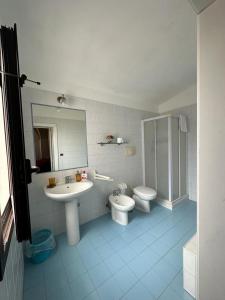 bagno con lavandino, servizi igienici e specchio di Masseria Triglie a Crispiano
