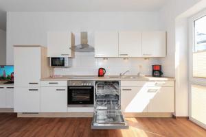 a kitchen with a dish rack in the middle of a kitchen at Haus Leuchtturm in Bensersiel +136 photos