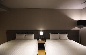 Postel nebo postele na pokoji v ubytování Chiayi Guanzhi Hotel
