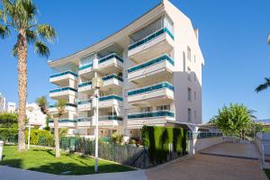 een wit appartementencomplex met palmbomen ervoor bij Estrella 2 1a Spaniahome in L'Alfas del Pi