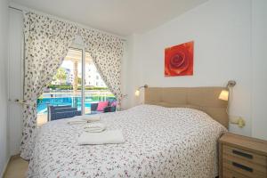 een slaapkamer met een bed en uitzicht op een zwembad bij Estrella 2 1a Spaniahome in L'Alfas del Pi
