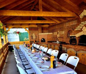 a long table with white chairs in a room at ECO-TIM in Moisei