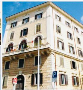 a large white building with a lot of windows at Charme Holidays Colosseum in Rome