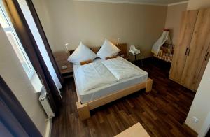 een slaapkamer met een bed met witte lakens en kussens bij Hotel Due Fratelli in Senftenberg