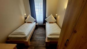 two beds in a small room with a window at Hotel Due Fratelli in Senftenberg