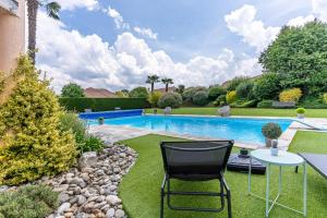 a pool with two chairs and a table in a yard at Reves2bulles in Ousse