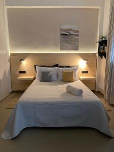 a bedroom with a large bed with white sheets and pillows at Tiny Square in Nafpaktos