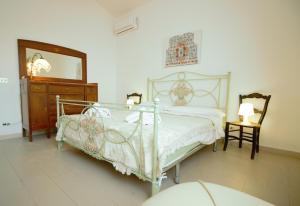 a bedroom with a bed and a dresser and a mirror at Villa Beatrice 25 in Siracusa