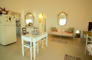 a living room with a white refrigerator and a table at Villa Beatrice 25 in Siracusa