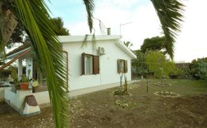 a white house with palm trees in front of it at Villa Beatrice 25 in Siracusa