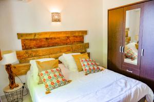 Schlafzimmer mit einem Bett mit weißer Bettwäsche und Kissen in der Unterkunft Sandra - Maison, Patio, Plage d'argent à 2 min - Verghia in Coti-Chiavari