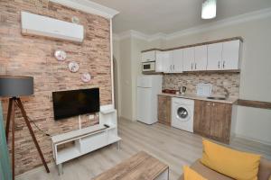 a living room with a tv on a brick wall at Cleopatra King Apart in Alanya