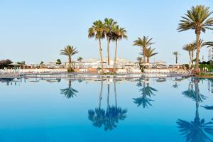 - une piscine avec des palmiers et de l'eau bleue dans l'établissement Iberostar Founty Beach All Inclusive, à Agadir