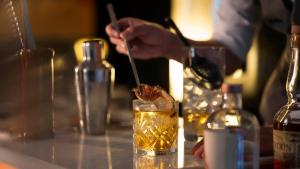 a person is stirring a drink with a stick at The Ritz-Carlton Shanghai, Pudong in Shanghai