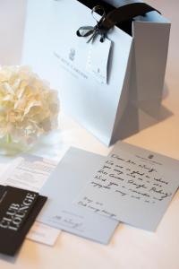 a table topped with papers and a bouquet of flowers at The Ritz-Carlton Shanghai, Pudong in Shanghai