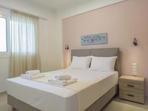 sypialnia z dużym białym łóżkiem z ręcznikami w obiekcie Renovated apartment 2 -Platanias w mieście Platanias