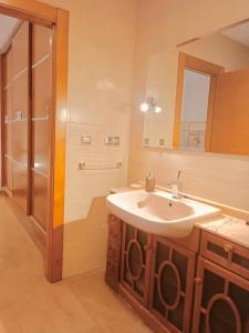 y baño con lavabo, espejo y ducha. en Laika House, en Granada