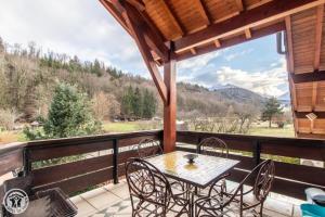 patio ze stołem i krzesłami na balkonie w obiekcie Gîte Annecy 07 - Au Royaume des Marmottes - Appt 07 w mieście Doussard