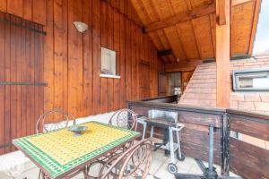patio ze stołem i krzesłami na ganku w obiekcie Gîte Annecy 07 - Au Royaume des Marmottes - Appt 07 w mieście Doussard