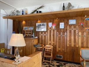 Habitación con pared de madera, mesa y sillas. en Hotel Schwarzsee en Zermatt