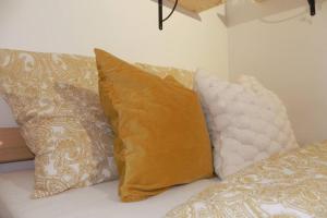 quatro almofadas sentadas numa cama num quarto em Le Nid du Bouvreuil em Rouen