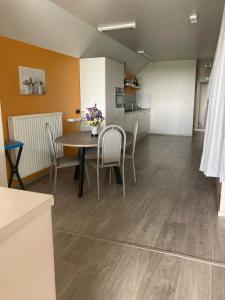 a room with a table and chairs and a kitchen at Hill44 in Zonnebeke