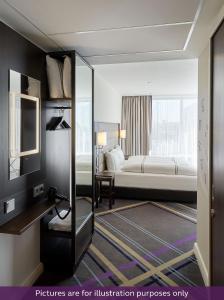 Pokój hotelowy z łóżkiem i lustrem w obiekcie Premier Inn Frankfurt City Centre w Frankfurcie nad Menem
