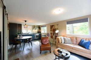 a living room with a couch and a table at Nature hideout at Veluwe nature park in Putten