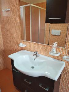 a bathroom with a white sink and a mirror at Bilo Olivieri Porto Cesareo in Porto Cesareo +29 photos