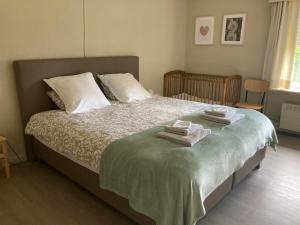 een slaapkamer met een bed met handdoeken erop bij Hill44 in Zonnebeke