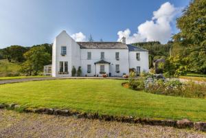 a large white house with a large yard at Killean Farmhouse B&B in Inveraray +29 photos